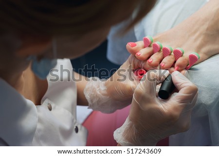 profesional nail technician sanding nails with machine