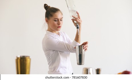 Professinal bartender girl juggling bottles and shaking cocktail at mobile bar table on white background - Powered by Shutterstock