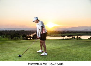 Professinal Golf Player On Golf Course. Pro Golfer Taking A Shot At The Sunset