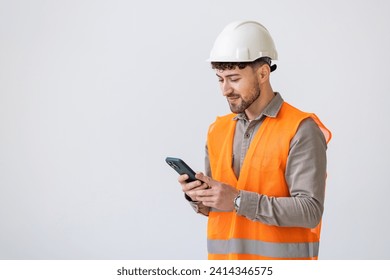 profession, construction and building - happy smiling male worker or builder in yellow helmet and overall with smartphone over white background - Powered by Shutterstock