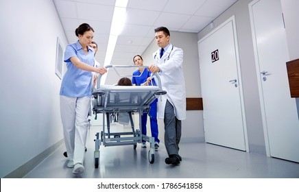 profession, people, health care, reanimation and medicine concept - group of medics or doctors carrying unconscious woman patient on hospital gurney to emergency - Shutterstock ID 1786541858