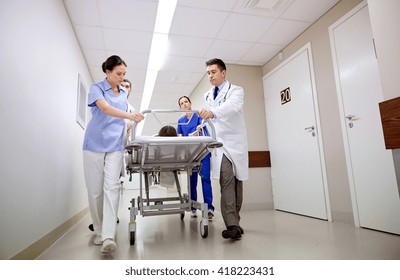 profession, people, health care, reanimation and medicine concept - group of medics or doctors carrying unconscious woman patient on hospital gurney to emergency - Shutterstock ID 418223431