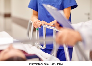 profession, people, healthcare, reanimation and medicine concept - medics or doctors carrying unconscious woman patient on hospital gurney to emergency room - Shutterstock ID 502044892