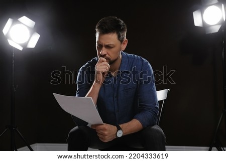 Professional actor reading his script during rehearsal in theatre