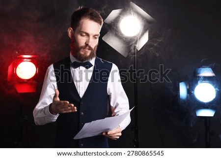 Professional actor in suit with script performing on stage