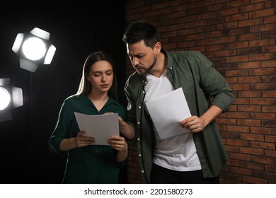 Professional actors reading their scripts during rehearsal in theatre - Powered by Shutterstock