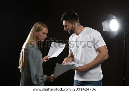 Professional actors reading their scripts during rehearsal in theatre