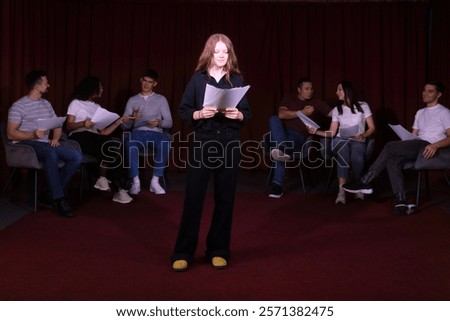 Professional actors reading their scripts during rehearsal in theatre