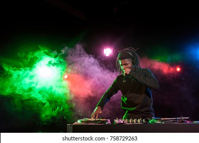 professional african american DJ in headphones with sound mixer in nightclub  - Powered by Shutterstock