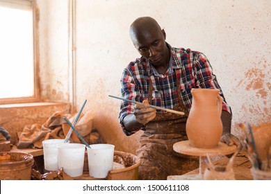 Professional African American Male Potter Painting Ceramic Pot In Pottery Workshop