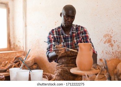 Professional African American Male Potter Painting Ceramic Pot In Pottery Workshop