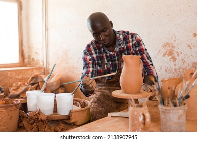 Professional African American Male Potter Painting Ceramic Pot In Pottery Workshop