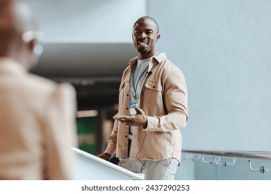 Professional African male speaker standing at a podium, engaging the audience during a corporate seminar, conveying confidence and expertise in a modern conference setting. - Powered by Shutterstock