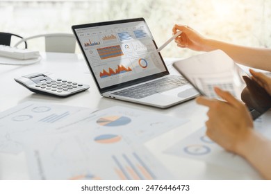 Professional analyzing financial data graphs, charts on laptop display at a modern workspace. Financial analysis or business evaluation concept - Powered by Shutterstock