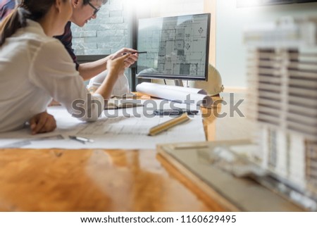 professional architect designer structural engineer team colleagues working office looking computer discussing building plan design project 