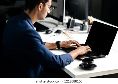 Professional architect dressed  in a business suit talking by phone and works on the laptop in the office - Powered by Shutterstock