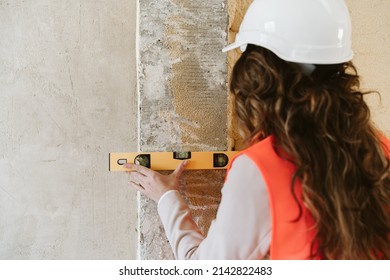 Professional Architect Woman In Construction Site Using Level Tool On Wall. Home Renovation