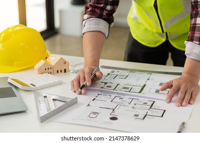 Professional Architect Working On Blueprints And Construction Plans. Building Engineers Calculate And Draft Building Construction Drawings, Civil Engineering, And Construction Business Concepts.