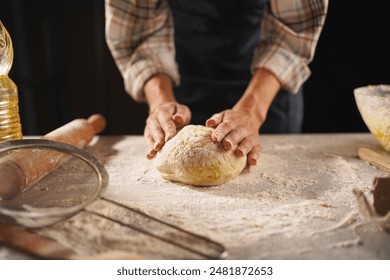 professional artisan baker chef is making loaf of dough, cooking pizza and other pastries in pizzeria kitchen. Close-up - Powered by Shutterstock