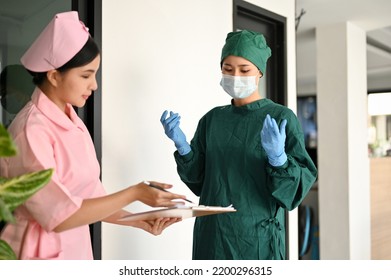 A Professional Asian Female Surgeon Or Neurologist Discussing With A Nurse And Checking A Medication History Patient's Record And Current Diagnosis Before Surgery.