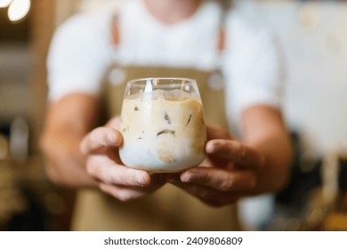 Professional Asian male barista pouring a cold milk in a glass. Happy male barista making a cup of iced latte coffee in a small coffee shop. Small business concept. - Powered by Shutterstock