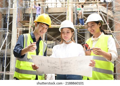 A Professional Asian Male Civil Engineer Is Explaining The Building Process And Details Of The Blueprint To A Beautiful Female Architect In Front Of The Construction Site.