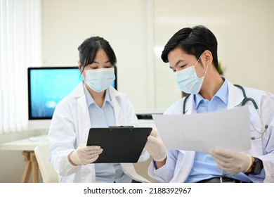 Professional Asian Male Doctor Medical Supervisor Giving A Medical Experiment Advice To A Female Scientist In The Lab.