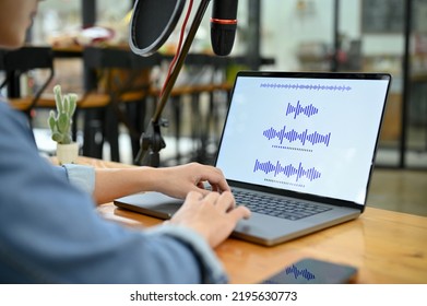 A Professional Asian Male Radio Host Or Radio Producer Adjusting The Record Sounds On His Laptop In The Studio. Close-up Image