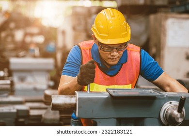 Professional Asian male staff skill worker focus precision detail working metal job with manual lathe cut fine tune machine. - Powered by Shutterstock