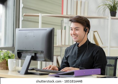 A Professional Asian Man Representative Hotline Service Provider That Focuses On Marketing By Telephone Consulting. Wear A Wireless Headset, Work In The Office, Customer Care Service Team.
