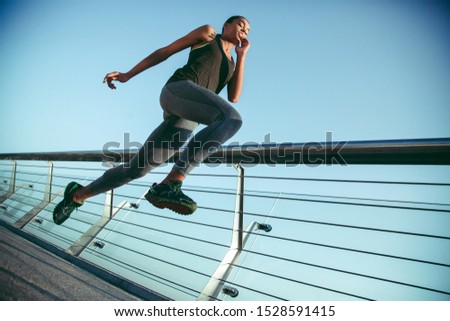 Professional athlete jumping on the bridge while exercising