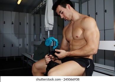 Professional Athlete Removing Weight Lifting Gloves Sitting In Gym's Locker Room After Workout