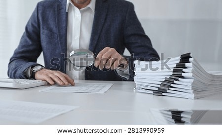 Professional auditor scrutinizing financial data and paperwork using a magnifying glass, performing a detailed tax investigation, legal discovery, and compliance analysis. Audit and taxes