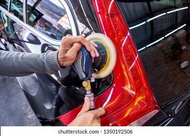 Professional Auto Detailer Hand Holding Air Random Orbital Sander Or Dual Action Polisher While Waxing Paint Surface Of Shiny Black Sedan. Car Detailing, Car Wash, And Paint Sealant Concept.