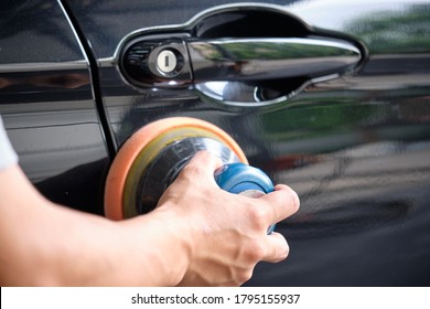 Professional Auto Detailer Hand Holding Air Random Orbital Sander Or Dual Action Polisher While Waxing Paint Surface Of Shiny Black Paint. Car Detail, Car Wash, And Paint Sealant Concept. 