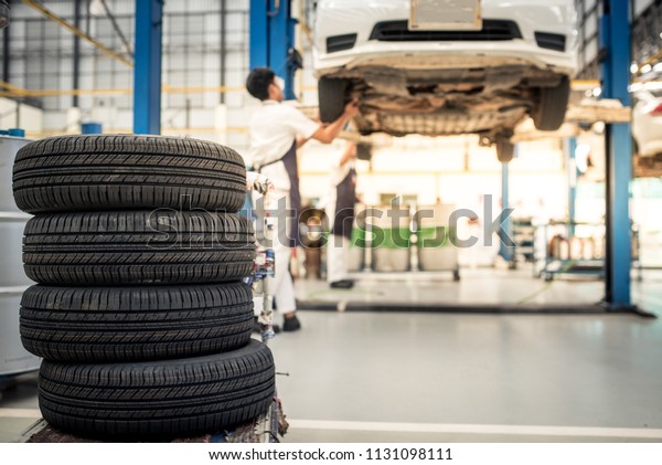 Professional auto mechanic changing a tire in auto\
repair shop