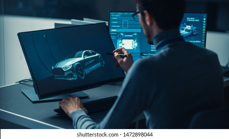 Professional Automotive Graphic Designer is Working on Concept Car Render with a Stylus Pen in a High Tech Innovative Laboratory with a Prototype Car Chassis.