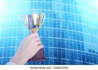 Professional Award, First Businessman, Successful Employee, Manager Cup, Market Leader, Financial Success, Competition Winner, Business Trophy In Hand On The Background Of Skyscrapers Offices