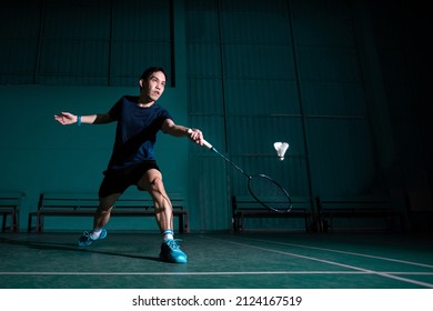professional badminton player use racquet hit shuttle cock or shuttlecock on court during warm up play before tournament competition in single man type in indoor court