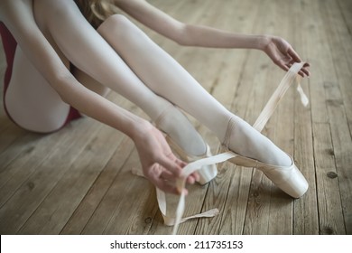 Professional ballerina putting on her ballet shoes.