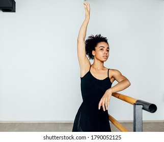 Professional ballet dancer practicing at barre in small studio - Powered by Shutterstock