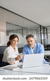 Professional bank manager consulting financial corporate client using laptop. Two busy professional executives team business people working together on computer at office meeting. Vertical.