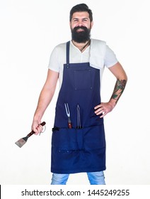 Professional barbecue utensil. Bearded hipster wear apron for barbecue. Roasting and grilling food. Tips cooking meat. How choose meat for steak. Tools for roasting meat outdoors. Picnic and barbecue.