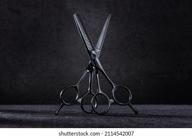 Professional Barber Hair Cutting Scissors And Thinning Shears. Hairdresser Salon Equipment Concept. On Black Background.