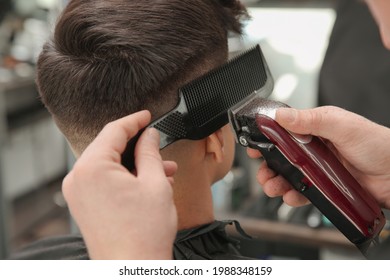 Professional Barber Making Stylish Haircut In Salon, Closeup