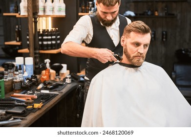 Professional barber shaving client's nape. Bearded handsome client getting stylish haircut. Confident man on regular appointment in barbershop. - Powered by Shutterstock