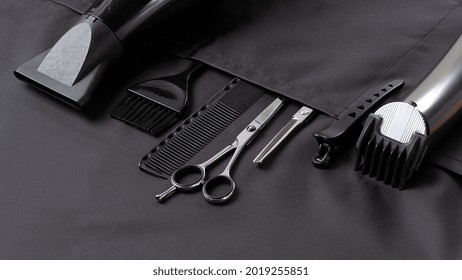 Professional barber tools, in the pocket, black stylist apron, horizontal, no people, - Powered by Shutterstock