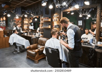 Professional barber using comb and electric shaver to cut side hair. Male customer getting stylish haircut. Side view of man on background of other hairdresser. - Powered by Shutterstock