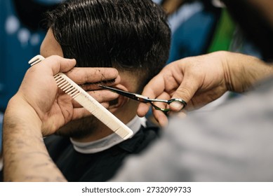 A professional barber using scissors and a comb to trim a client's hair in a modern barbershop.