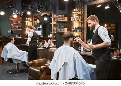 Professional barbers working on client hair in barbershop. Male hairstylists cutting hair in modern ambiance, with rustic wooden shelves stocked with various grooming products. - Powered by Shutterstock